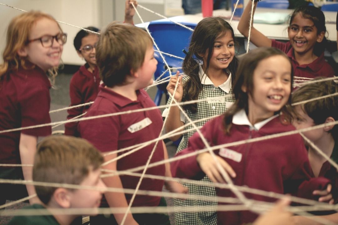 Children in classroom use string to understand shapes