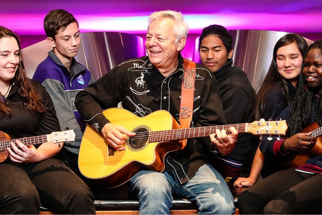 Guitarist Tommy Emmanuel playing with five aspiring young guitarists