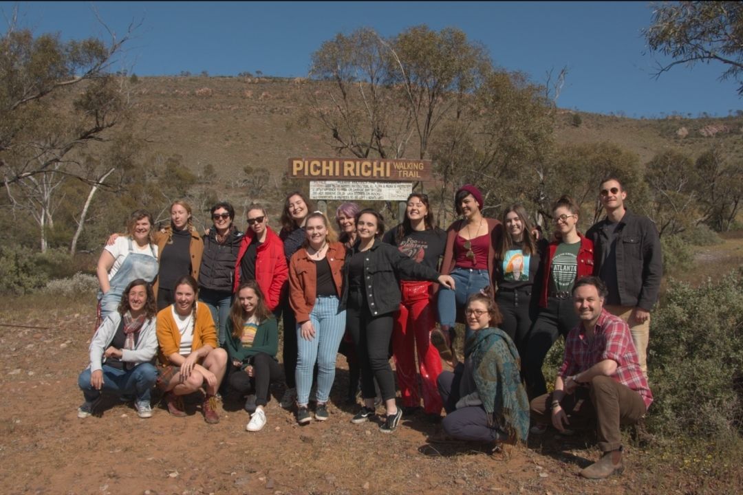 A group of writers standing in front of a sign reading Pichi Richi