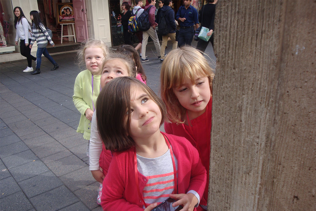 four children looking at a post