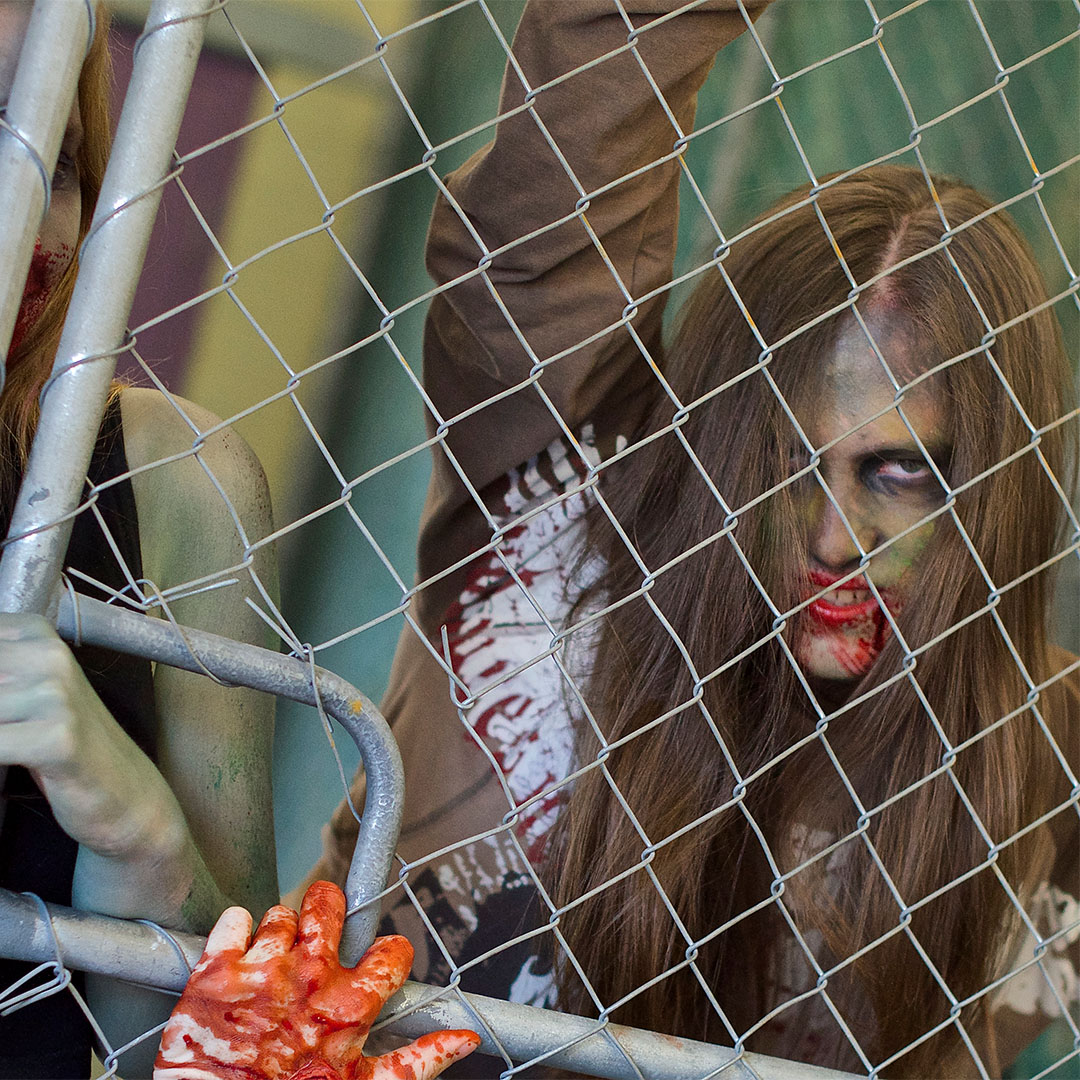Female zombie behind a gate trying to break through
