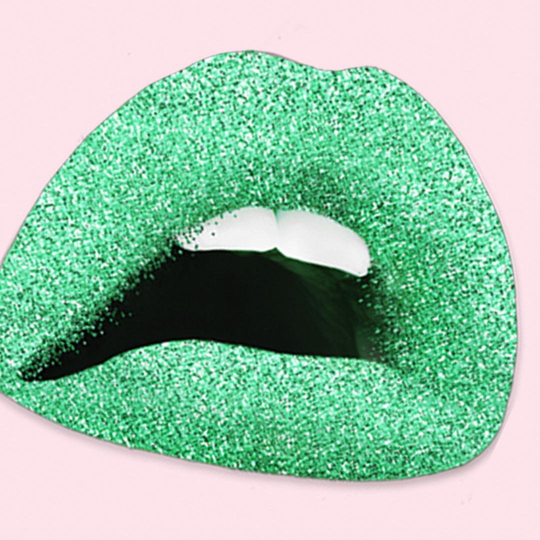 Open lips covered in green glitter with two front teeth showing