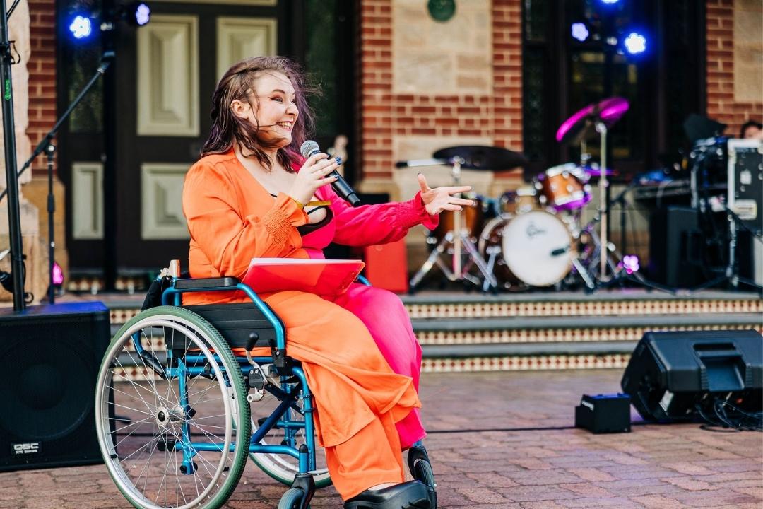 Emerging Creative Producer Diana Devine in her wheelchair MCing Backyard Picnic